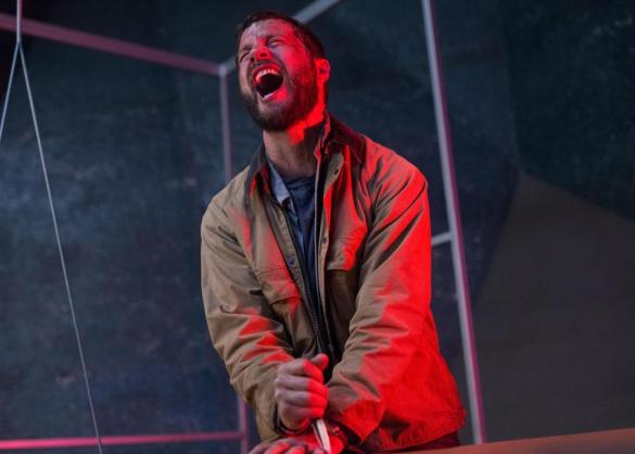 Logan Marshall-Green cries out in pain from stabbing his own hand in the sci-fi movie Upgrade.