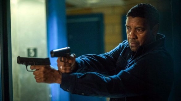 Denzel Washington holding two pistols, crossing his arms and leaning around a corner in The Equalizer 2.