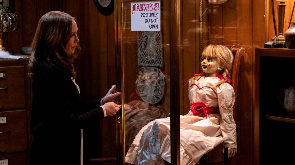 Vera Farmiga locks up Annabelle the doll in a glass cage in the horror movie ANNABELLE COMES HOME
