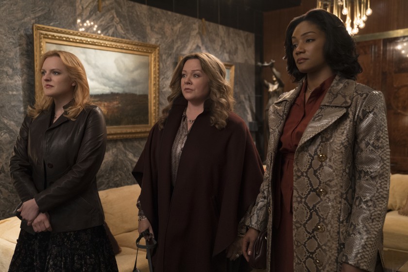 Elisabeth Moss, Melissa McCarthy, and Tiffany Haddish stand seriously in the movie The Kitchen