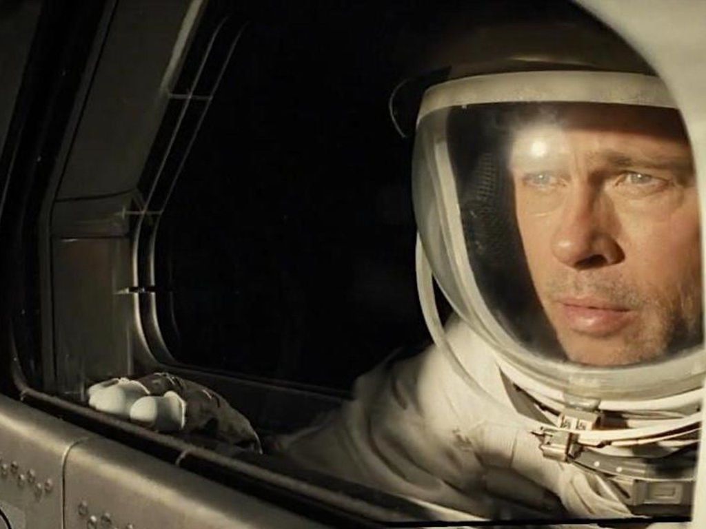 In a spacesuit Brad Pitt looks out the window of a spacecraft in the movie Ad Astra