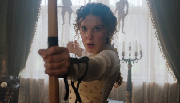 Millie Bobby Brown looks shocked after releasing an arrow from her bow in the movie Enola Holmes
