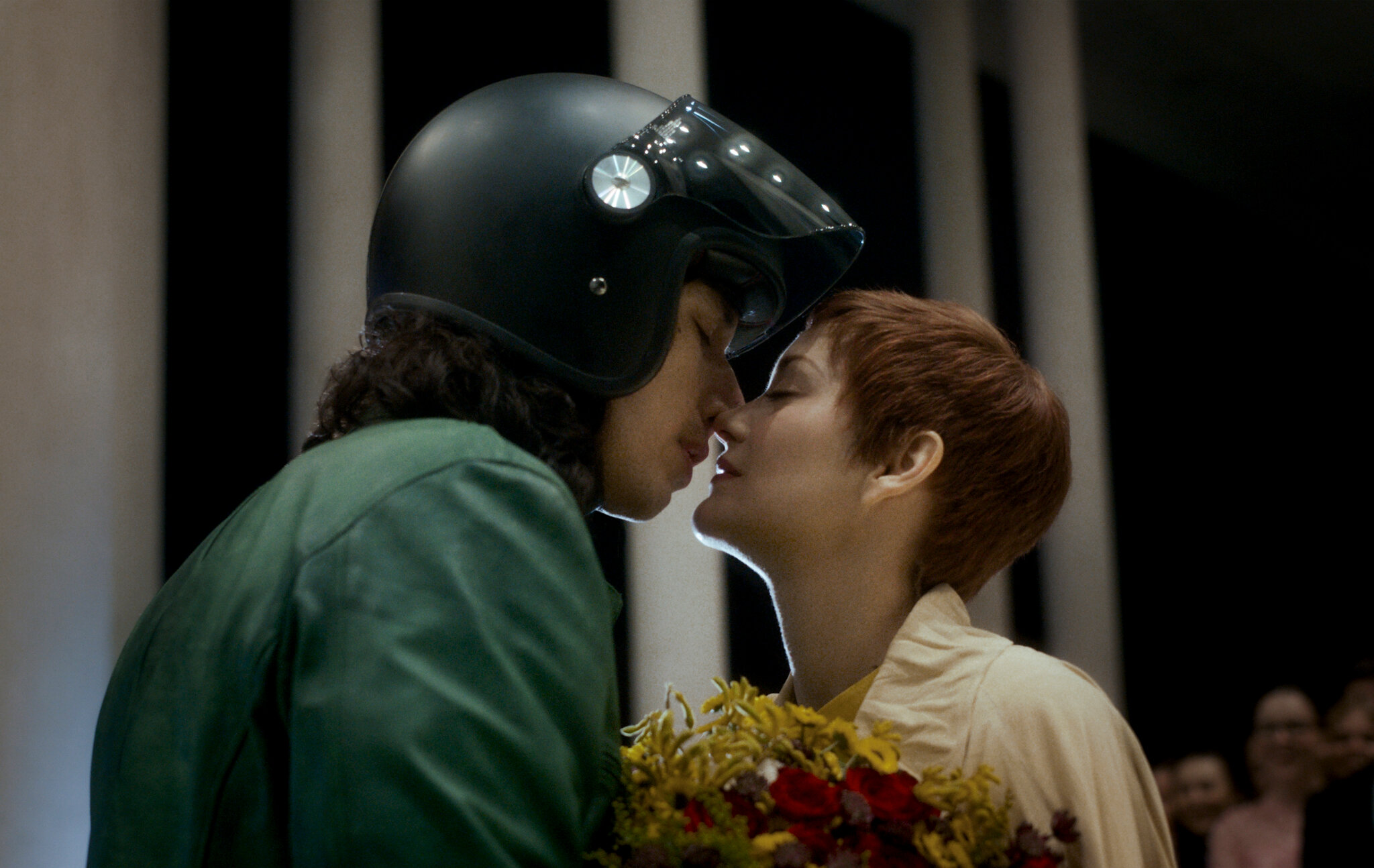 Adam Driver wears a motorcycle helmet as he's about to kiss Marion Cotillard in the movie Annette