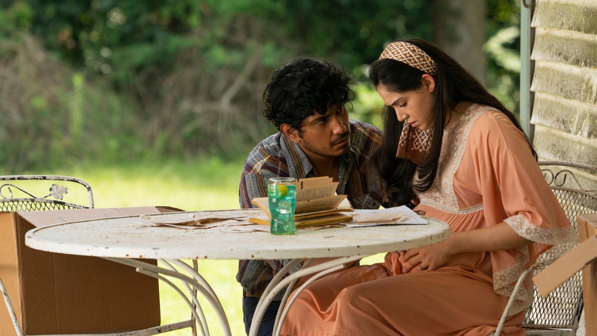 Tenoch Huerta comforts Ariana Guerra sitting at a table in the movie Madres