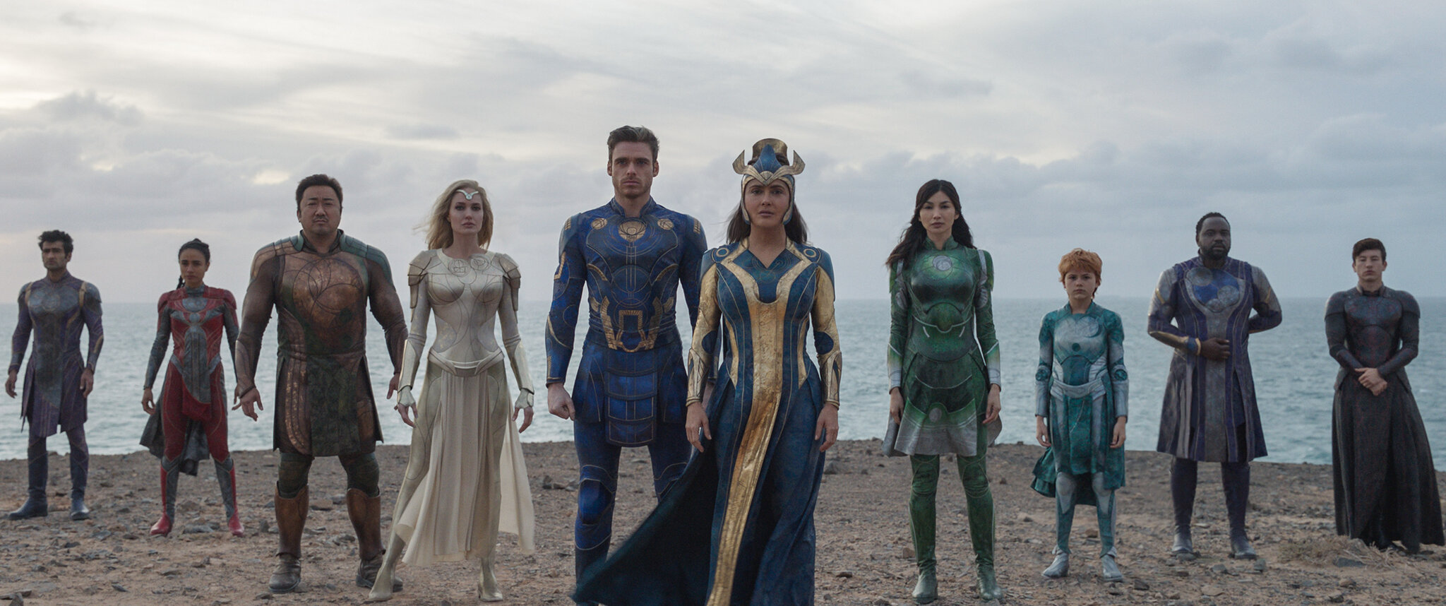 The cast of heroes in Marvel's Eternals standing together on a beach